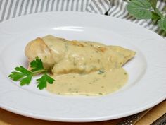 a white plate topped with meat covered in gravy