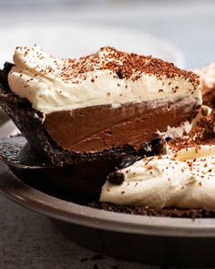 there is a piece of chocolate pie on the plate with whipped cream and sprinkles