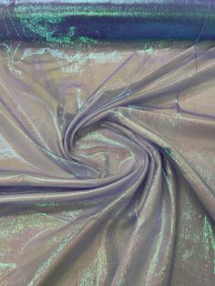 the fabric is shiny and blue with green streaks on it's edges, as well as an iridescent background