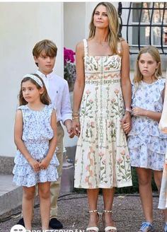 an image of a woman and two children holding hands