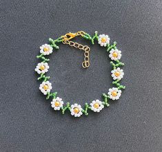 Pretty daisy design  encompassed in anklet  White and green glass seed beads golden yellow glass pearl bead centers finished with lobster clasp & extension chain and charm Length option available  Your order will be sent in an organza gift pouch shipping Free delivery on all uk orders International is by Airmail,please see listings for destination/rate I am not a big business but a one woman operation. I pride myself with attention to detail and strive to offer a swift and efficient service. If anything is not to your complete satisfaction I would appreciate to be given the opportunity to put it right BEFORE feedback is left. Any problems: Please send me a message before opening a case as most problems can be quickly & easily resolved . Summer Flower Shaped Beaded Chain Jewelry, Summer Gold Beaded Bracelets, Dainty Beach Jewelry For Spring, Dainty Spring Beach Jewelry, Summer Flower Charm Bracelet Jewelry, Spring Jewelry With Colorful Beads In Gold, Dainty Beaded Bracelets For Summer Gift, Adjustable Dangle Jewelry For Spring, Dainty Beaded Bracelets For Summer