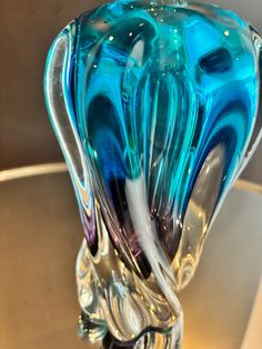 a blue glass vase sitting on top of a table