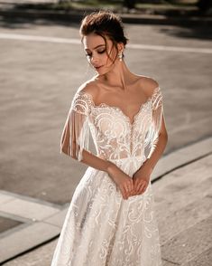 a woman in a white dress standing on the street