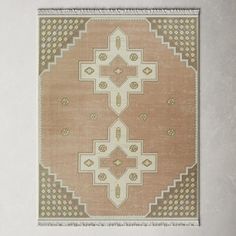 an old rug hanging on the wall in front of a white frame with a black border