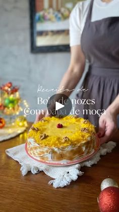 a woman is decorating a cake with yellow frosting and cherries on it