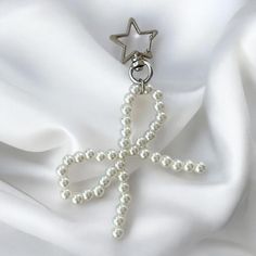 a cross made out of pearls with a star on the top is laying on a white fabric