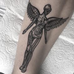 a woman's leg with a skeleton and angel tattoo on it