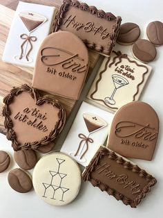 decorated cookies are arranged in the shape of hearts and wine glasses on a table top