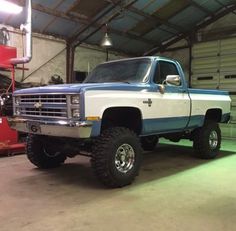 a large blue and white truck parked in a garage