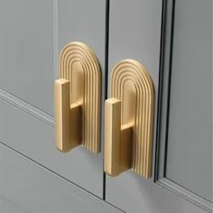 two gold handles on the front of a gray cabinet