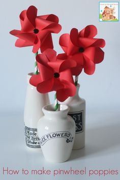 three vases with red paper flowers in them