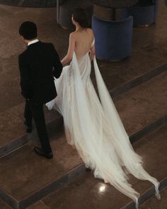 a bride and groom walking down some steps