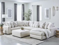 a living room with white furniture and large windows