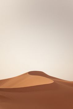 a lone camel standing in the middle of an empty desert area with no people on it