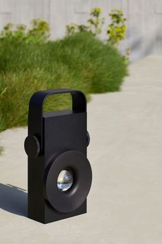 a black object sitting on top of a cement ground