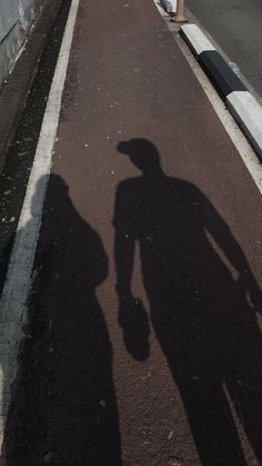 the shadow of a person standing next to a fire hydrant on a city street