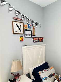 a bed room with a neatly made bed and lots of pictures on the wall above it