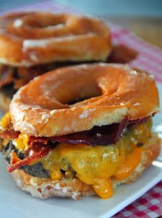 two bacon, egg and cheese bagels on a white plate with a red checkered tablecloth