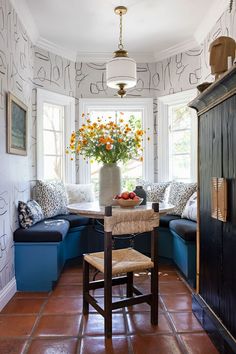 a living room filled with lots of furniture and flowers in a vase on top of a table