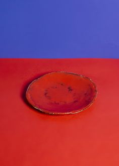 a red plate sitting on top of a red table