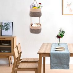 a wooden table with two baskets hanging from it's sides and flowers in the vase