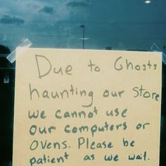 a sign posted on the side of a car door that says due to ghost hunting our store we cannot use our computers or ovens please be patient as we wait