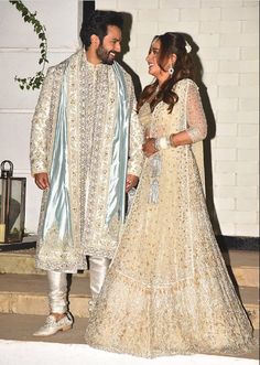 a man and woman dressed in white standing next to each other