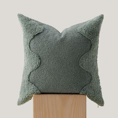 a green pillow sitting on top of a wooden stand