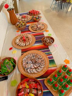 a table topped with lots of food on top of a white table covered in candy