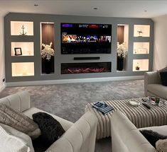 a living room filled with furniture and a flat screen tv mounted on the wall above a fire place