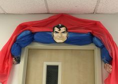 a superman mask hanging from the side of a door with a red cape over it