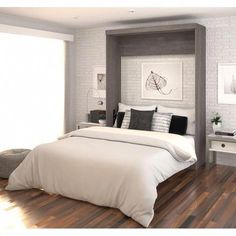 a large white bed sitting inside of a bedroom next to a wooden floored floor