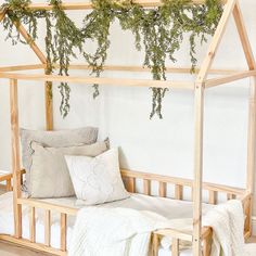 a bed with pillows and plants hanging from it