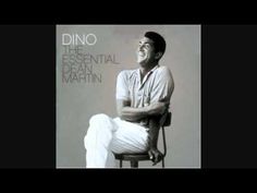 a man sitting on top of a stool next to a white wall with the words dino