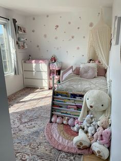 there is a teddy bear and other stuffed animals on the floor in front of a bed