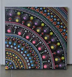 a painting on the wall with dots and circles in black, pink, blue, green, yellow