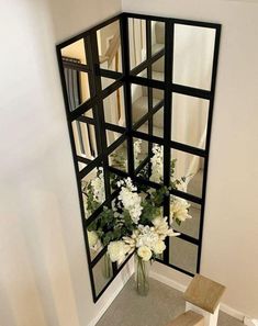 a vase filled with white flowers next to a mirror