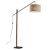 a floor lamp with a fabric shade on the top and an iron pole underneath it