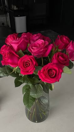 a vase filled with red roses on top of a table