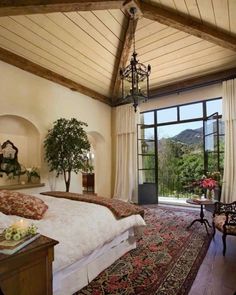 a bedroom with a large bed and a chandelier hanging from it's ceiling