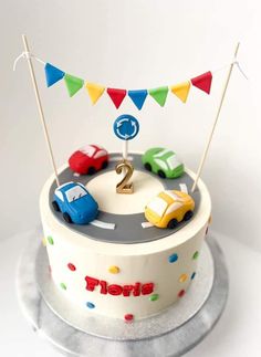 a birthday cake decorated with cars and flags