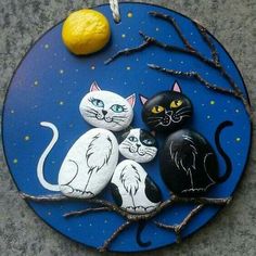 three black and white cats painted on rocks