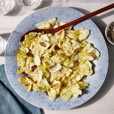 a blue and white plate topped with salad next to two bowls filled with sauces