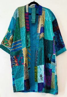 Short Patchwork Cotton Kimono Duster. Expertly designed with quality kantha stitching. This delightful, handmade cotton patchwork kimono is impressive. A full kaleidoscope of colors, blending with all of your basics. Constructed in fresh, quality cotton. Designer influenced and unique. Created as a traditional short kimono with an extra wide front band. Luscious color of turquoise. Can be worn open as a duster jacket or wrapped as kimono. Embroidery is carried through out the garment and finishe Green Traditional Kimono With Patchwork, Traditional Green Kimono With Patchwork, Handmade Multicolor Cotton Kimono, Multicolor Cotton Kimono With Patchwork, Multicolor Cotton Patchwork Kimono, Cotton Kimono With Patchwork And Kimono Sleeves, Multicolor Patchwork Kimono For Festivals, Festival Kimono With Green Patchwork, Festival Green Kimono With Patchwork