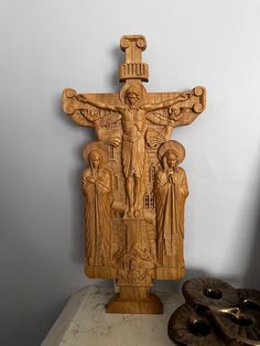 a carved wooden crucifix with three people on it