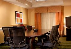 a conference room table with chairs and television