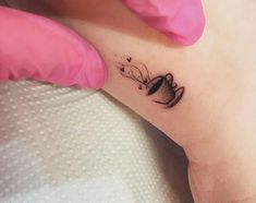 a woman's foot with a tattoo on her left leg and a cup in the middle