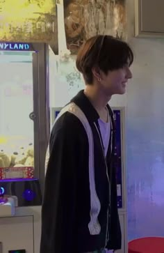 a young man standing in front of a vending machine