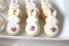 decorated cookies in the shape of bunnies with bunny ears and sprinkles