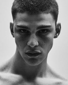 a black and white photo of a young man with frecky hair on his face